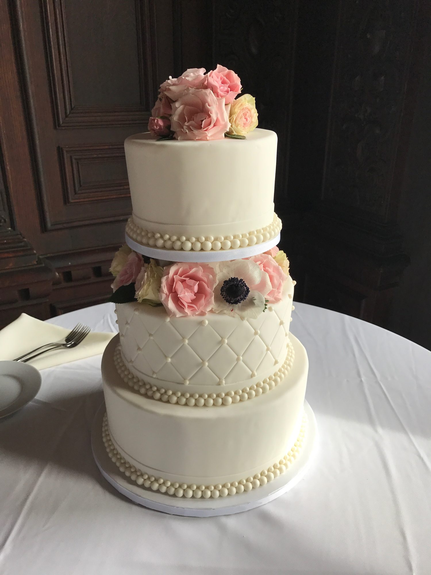 Wedding cake with pearls and fresh flowers